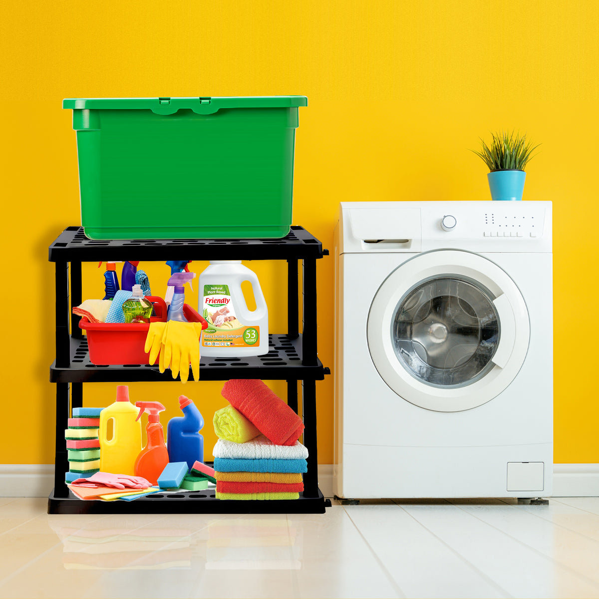 Oskar 3-tier storage shelves with laundry supplies and a green tote on it set up beside a white washing machine in front of a yellow wall